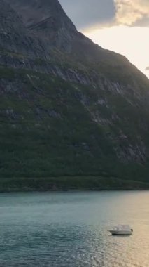 Zaman ayarlı. Kıyıdan uzakta küçük bir balıkçı teknesi. Hızlı su hareketi. Dikey video. Uzaklaştır. 