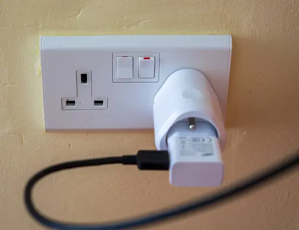 White electrical socket with connected connectors and black cable.