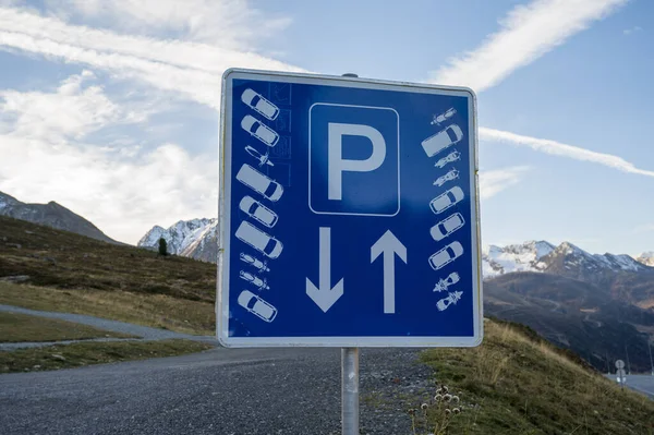Blue road sign with marked parking high in the mountains.