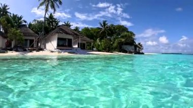 Deniz seviyesinden, evleri ve denizi olan tropikal bir adaya bak. Maldivler.