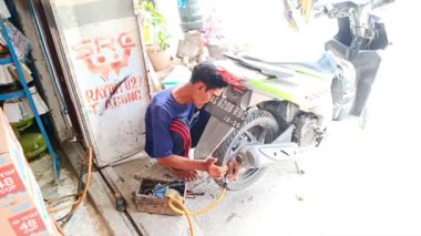 Tulungagung - 15 Ocak 2024, Geleneksel Lastik Tamircisi, Endonezyalı Tamirci Sınırlı Ekipmanlı Motorsiklet Tekerleği Tamiri