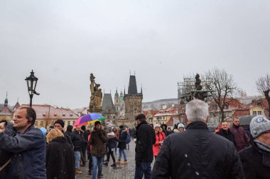 Soğuk bir kış gününde Prag 'daki Charles Köprüsü' ndeki insanların fotoğrafı.