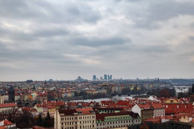 Prag 'ın ortaçağ şehri kışın panoramik manzarası. Uzaktaki Charles Köprüsü 'nü ve gökdelenleri kullanabilirsin. Hava bulutluydu.