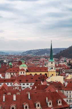 Prag 'ın ortaçağ şehri kışın panoramik manzarası. Arka planda bir kilise ve dağlar var.
