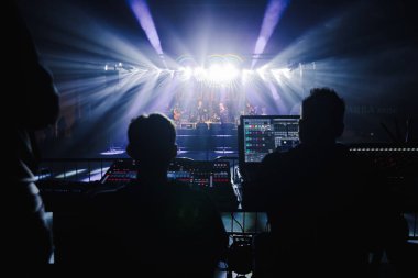 İçerideki bir müzik etkinliğindeki insanların silueti.