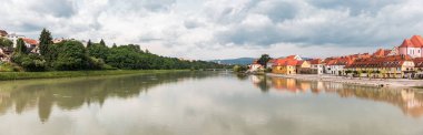 Maribor şehrinin manzarası ve Drava nehri doğa ve binalarla dolu.