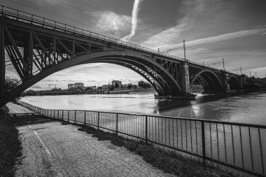 Şehir manzarası Maribor ve arkasında binalar olan tren köprüsü. Bulutlu bir gökyüzü