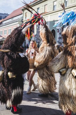 Kurtlarla çevrili bir kadın. Slovenya 'daki karnaval maskeli bir kuren. İlkbaharda giyilecek geleneksel bir kostüm. Kuran bizim kültürümüzde var.