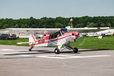 Bir uçak ve yerde bir pilot var. Havaalanında tamircisi olan küçük bir uçak.