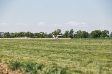 Çimen pistinde bir uçak. Uçak uçmaya hazır. Bu insanlar için bir ulaşım aracı.
