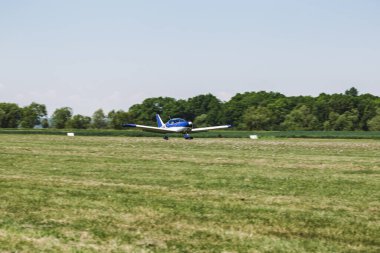 Çimen pistinde bir uçak. Uçak uçmaya hazır. Bu insanlar için bir ulaşım aracı.