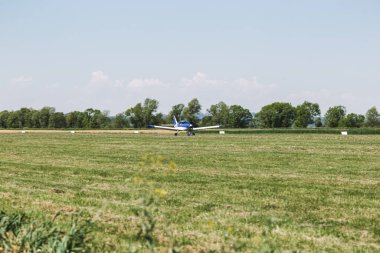 Çimen pistinde bir uçak. Uçak uçmaya hazır. Bu insanlar için bir ulaşım aracı.