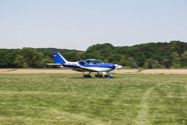 Çimen pistinde bir uçak. Uçak uçmaya hazır. Bu insanlar için bir ulaşım aracı.