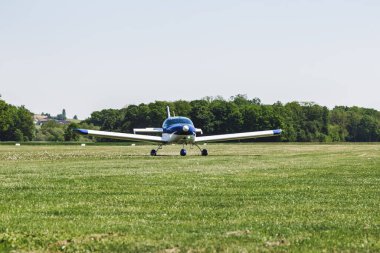 Çimen pistinde bir uçak. Uçak uçmaya hazır. Bu insanlar için bir ulaşım aracı.