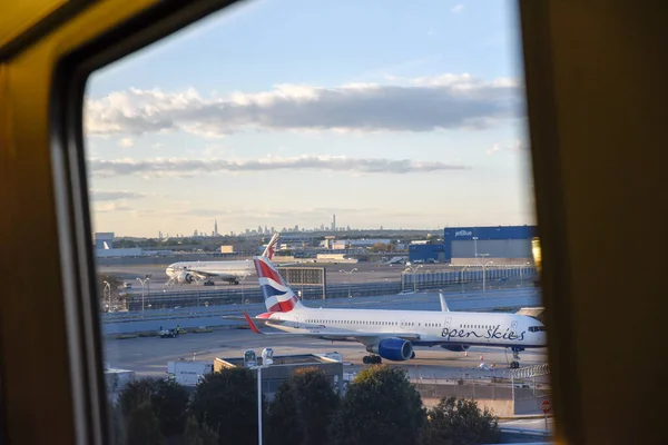 New York, New York, ABD - 5 Eylül 2021: JFK havaalanı terminalinin havadan görünüşü, yükselen uçaktan Delta havayolları uçakları ile kule ve apron