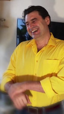 Yakışıklı bir adam, birinin şakasına bulaşıcı bir şekilde güler..