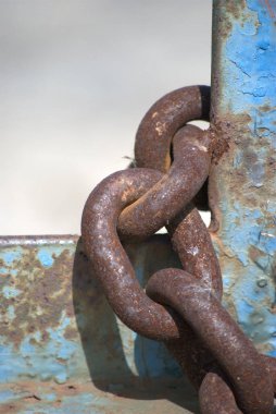Kumsaldaki eski paslı zincir.