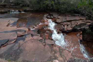 Ortada küçük bir şelale olan bir şelale.