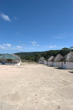 Birkaç kulübesi ve birkaç adamı olan bir sahil.