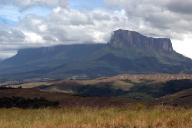 Gökyüzünde birkaç bulut olan bir dağ
