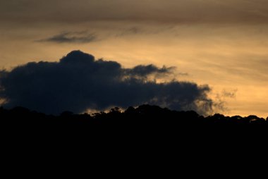 Kara bulutla gökyüzünde uçan bir uçak.