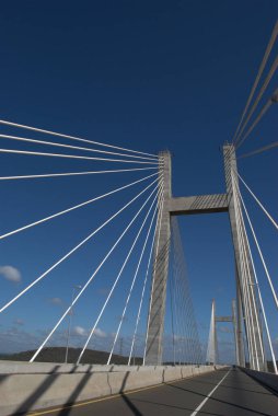 Gökyüzü arkaplanı ve üzerinde araba olan bir köprü.