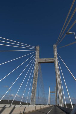 Gökyüzü arkaplanı ve üzerinde araba olan bir köprü.