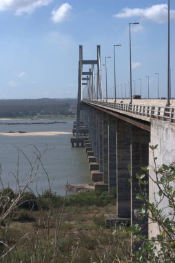 Gökyüzü arkaplanı olan bir su kütlesinin üzerinde bir köprü