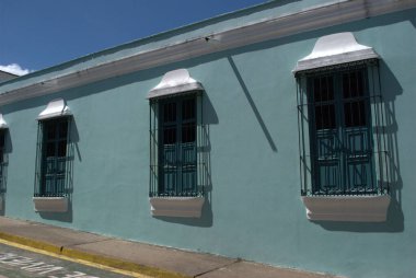 Mavi duvarı ve sarı kaldırımı olan bir bina.