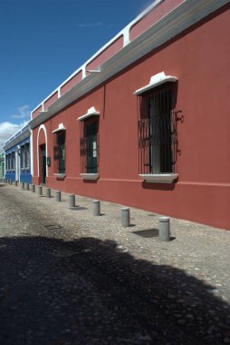 Beyaz çerçeveli ve pencereli kırmızı bir bina.