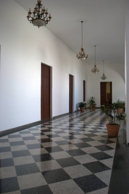 Kareli zemini ve avizesi olan bir koridor.