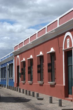 Önünde motosiklet olan kırmızı bir bina.