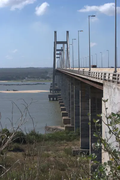 Gökyüzü arkaplanı olan bir su kütlesinin üzerinde bir köprü