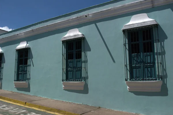 Mavi duvarı ve sarı kaldırımı olan bir bina.