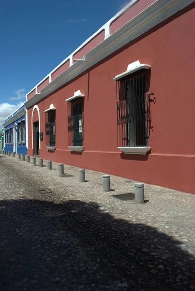 Beyaz çerçeveli ve pencereli kırmızı bir bina.