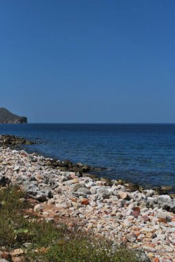 Denize ve kayalara bakın.