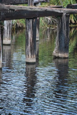 Temiz bir gökyüzünün altında ahşap bir çitle çevrili güzel bir nehir görüntüsü.