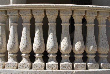 Parkta metal parmaklıklı taş bir çitin yakın çekimi.