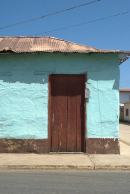 Penceresi ve mavi gökyüzü olan eski ahşap bir ev.