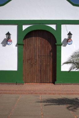 Ahşap çatılı yeşil ve beyaz bir binanın dikey görüntüsü.