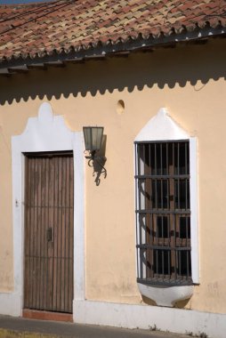 Pencereleri ve beyaz duvarı olan eski ahşap kapı.