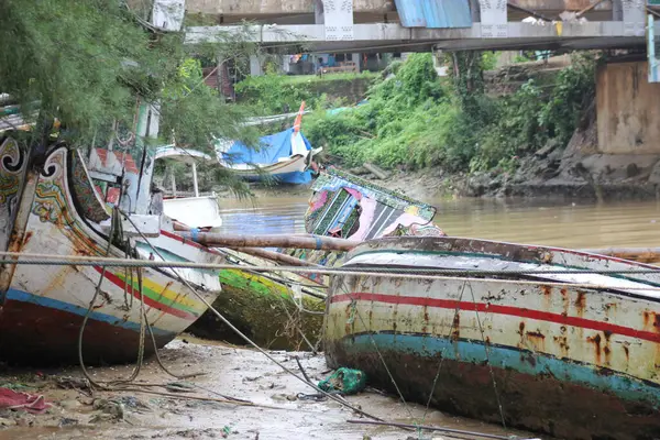 Hasarlı bir balıkçı teknesi nehir kenarında terk edilmiş.