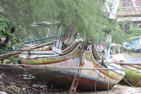Hasarlı bir balıkçı teknesi nehir kenarında terk edilmiş.
