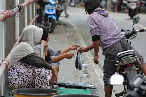 Köprü üzerinde aktarımlar. Balıkçı, balıklarını nehir kıyısına giden köprüde satıyor.