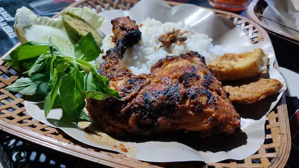 Lalapan adlı geleneksel Endonezya yemeği ahşap tabakta ızgara tavuk ve ızgara balık, sebze, kızarmış tempeh ve baharatlı acı biber soslu pilav var.