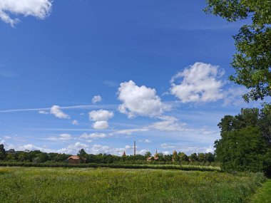 Mavi gökyüzü, beyaz kabarık bulutlar, tarla. Güneşli güzel bir gün. Fotoğraf 1