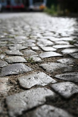 Sığ alan derinliği, taşların ışıldayan yüzeyini vurguluyor ve karamsar ve atmosferik şehir manzarası yaratıyor. Tarih, nostalji, eski Avrupa sokakları ve dokular için idealdir..