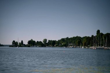 Sakin bir gölde yatları ve tekneleri olan bir marina. Denizde yelken açmak, kayak yapmak, kürek çekmek ve dinlenmek için ideal bir yer..