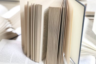 Kitap yığını, kapatın. Kütüphanede masanın üzerinde açık bir kitap. Okul konseptine geri dönelim. Masada bulanık kitaplık arkaplanı olan bir kitap aç 