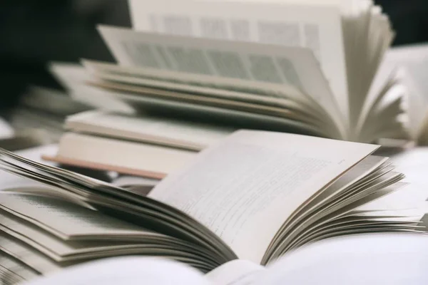 Kitap yığını, kapatın. Kütüphanede masanın üzerinde açık bir kitap. Okul konseptine geri dönelim. Masada bulanık kitaplık arkaplanı olan bir kitap aç 